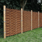 A natural wicker fence panel with vertical wooden posts and metal bands, shown installed outdoors on a grassy lawn with trees in the background.